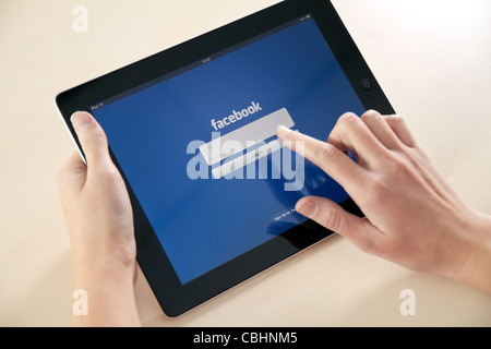 Facebook launch application for iPad in October 10, 2011. Girl trying to log in using Apple iPad2. Stock Photo