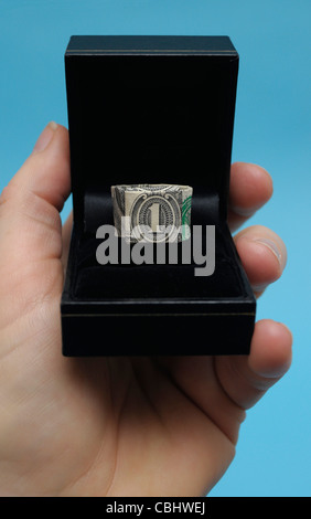 America First, Trump is wooing the world as economics dominate politics. Photo shows Origami ring made from a one dollar bill in a jewellery box. Stock Photo