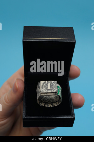 America First, Trump is wooing the world as economics dominate politics. Photo shows Origami ring made from a one dollar bill in a jewellery box. Stock Photo