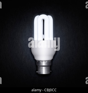 Bright Energy Saver Light Bulb on a dark background Stock Photo