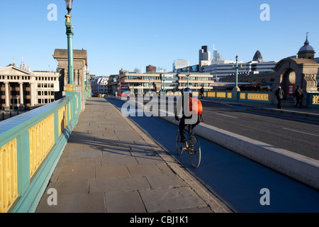 cyclist commuter using the cycle lane on southwark bridge towards the city of london england united kingdom uk Stock Photo