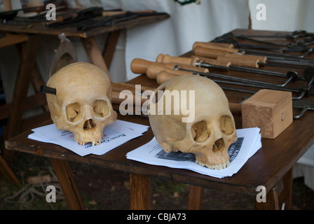 Pair of skulls next to old medical instruments on table in tent of historical reenactor at Robin Hood festival Stock Photo