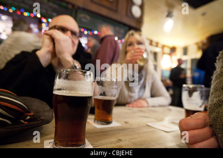 People talking and drinking beer in a pub interior, Aldeburgh Suffolk UK Stock Photo