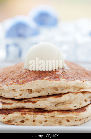 Fresh buttermilk pancakes with scoop of butter on white plate Stock Photo