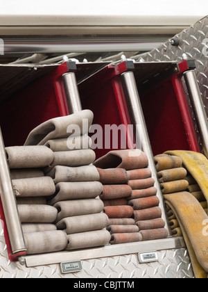 Fire hoses folded in fire truck. Stock Photo