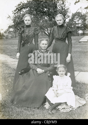 Circa 1900 antique photograph of three generations of women -- mother, daughter, granddaughter -- in Victorian dress. Stock Photo