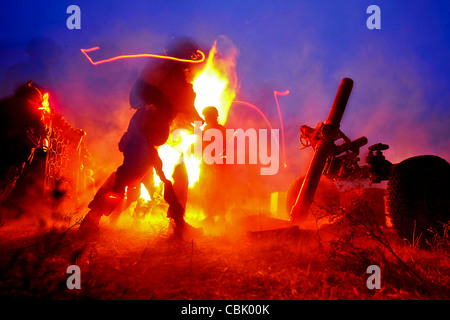 US Marines firing 120m mortar system at night. Stock Photo
