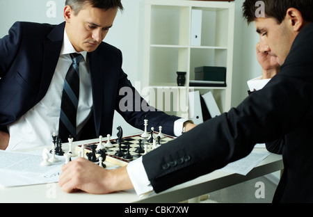 Image of two businessmen looking at chessboard while playing chess Stock Photo