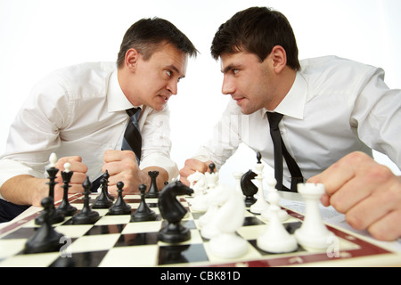 Two men looking at each other aggressively while playing chess Stock Photo