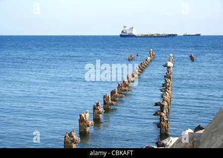 Old broken pier waits the ship. Stock Photo