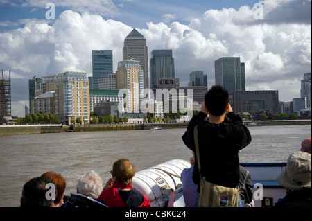 Sightseers on a Thames River boat guided tour viewing Docklands Canary Wharf, London, UK Stock Photo