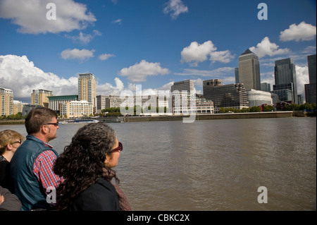 Sightseers on a Thames River boat guided tour viewing Docklands Canary Wharf, London, UK Stock Photo