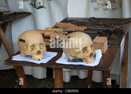 Pair of skulls next to old medical instruments on table in tent of historical reenactor at Robin Hood festival Stock Photo