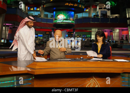 Al Jazeera satellite TV anchors Habib Ghribi and Lina Zahreddine read a news bulletin from studios in Doha, Qatar Stock Photo