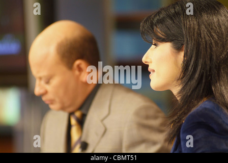 Al Jazeera satellite TV anchors Habib Ghribi and Lina Zahreddine read a news bulletin from studios in Doha, Qatar Stock Photo