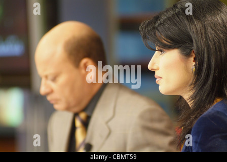 Al Jazeera satellite TV anchors Habib Ghribi and Lina Zahreddine read a news bulletin from studios in Doha, Qatar Stock Photo