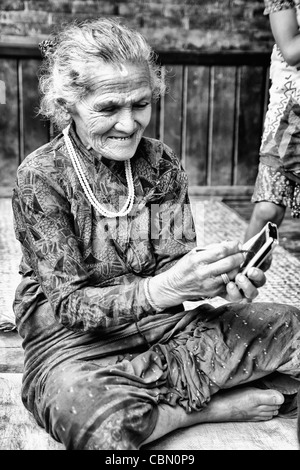 Great image of modern technology with old woman and new PDA computer in village of Bhaktapur a town near Kathmandu Nepal Stock Photo