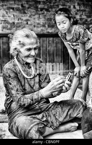 Great image of modern technology with old woman and new PDA computer in village of Bhaktapur a town near Kathmandu Nepal Stock Photo