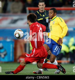 Yong Hak An of North Korea (L) defends against Robinho of Brazil (R) during a FIFA World Cup match at Ellis Park Stadium. Stock Photo