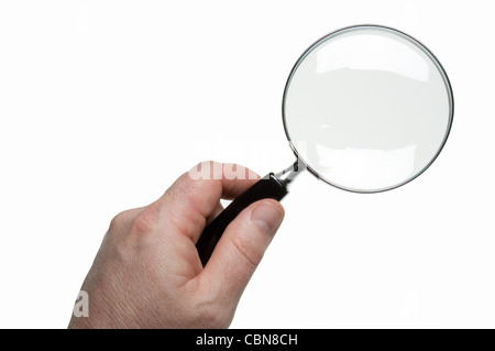 Single hand holding glass magnifier over white surface. Stock Photo