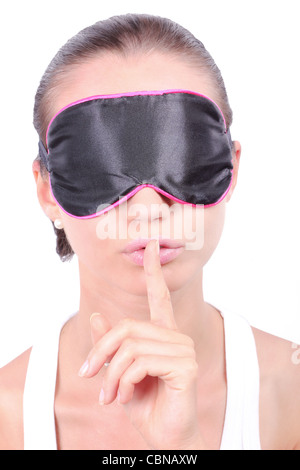 Woman in sleeping mask making a keep it quiet gesture Stock Photo