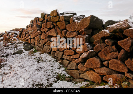 Sunrise hitting a gritstone wall at Baslow Edge Peak District Stock Photo