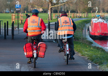 Two postmen on their bikes along the river Cam in Cambridge. England. Stock Photo