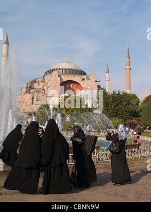 Women in abaya cloak stand in front of the Aya Sofya, Istanbul, Turkey Stock Photo