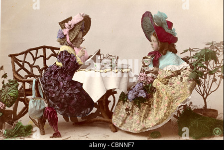 Two Victorian Little Ladies Having Tea Stock Photo