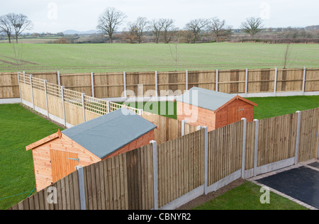 Wooden fences around the gardens of modern new homes built in a rural Shropshire location looking out over open countryside Stock Photo