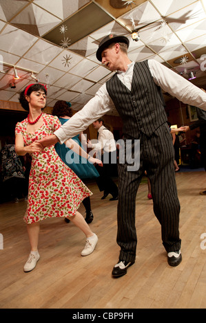 People swing dancing Lindy hopping and jiving to retro 40s 50s music at a club, UK Stock Photo