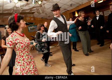 People swing dancing Lindy hopping and jiving to retro 40s 50s music at a club, UK Stock Photo