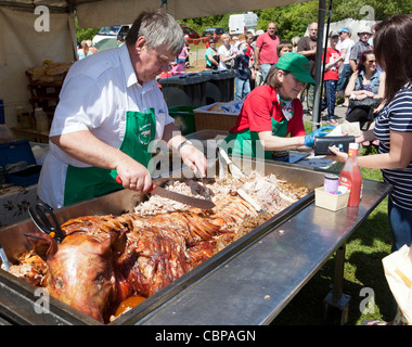 Carving a roast pig at Garn Lakes Country Fayre Blaenavon Wales UK Stock Photo