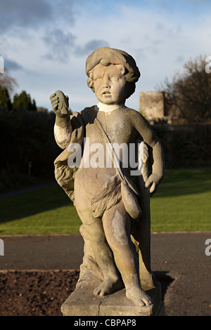 Statue of boy carrying sachel in the gardens of St Fagan's castle Cardiff Wales UK