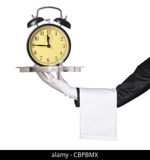 A hand holding a silver tray with a retro clock alarm on it Stock Photo