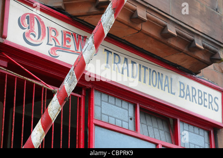 Red and white stripped pole of a traditional barbers shop. Stock Photo