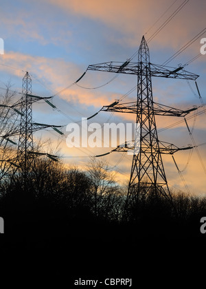 Electricity pylons set against a sunset in Scotland Stock Photo