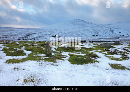 Pennine Way Footpath Marker Stone on Bracken Rigg With a Snow Covered Noon Hill Behind Upper Teesdale County Durham UK Stock Photo