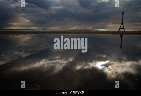 The river Mersey flows under moody skies past Crosby beach Stock Photo