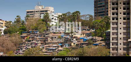 Slum housing and slum dwellers next to apartment blocks in Bandra area of Mumbai, India from Bandra Worli Sealink Road Stock Photo