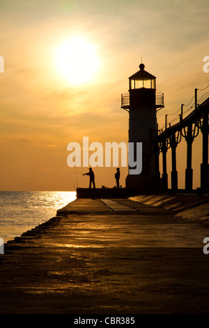 Fishermen at sunset on a lighthouse pier in St. Joseph, Michigan Stock Photo