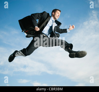 Caucasian businessman jumping in air Stock Photo