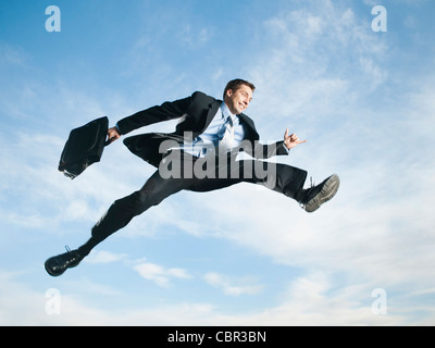 Caucasian businessman jumping in air Stock Photo