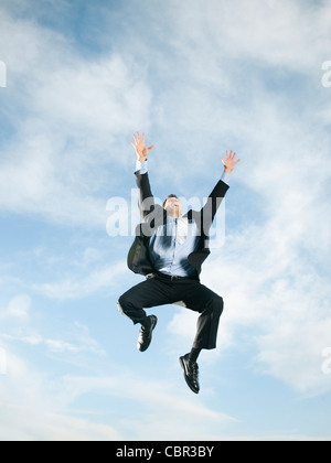 Caucasian businessman jumping in air Stock Photo