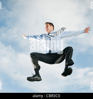 Caucasian businessman jumping in air Stock Photo