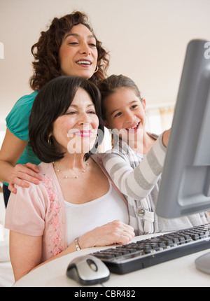 Family using computer together Stock Photo