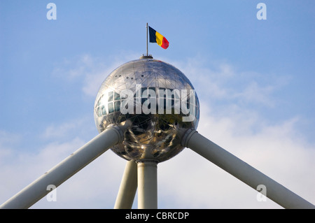 Horizontal close up of the uppermost top sphere of the Atomium monument in Heysel Park with the Belgian flag against a blue sky. Stock Photo