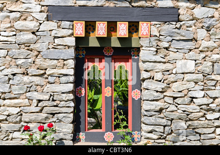 Traditional Himalayan style stone & wood window in wall of Bhutan's pavilion at Royal Flora Ratchaphruek in Chiang Mai Thailand Stock Photo