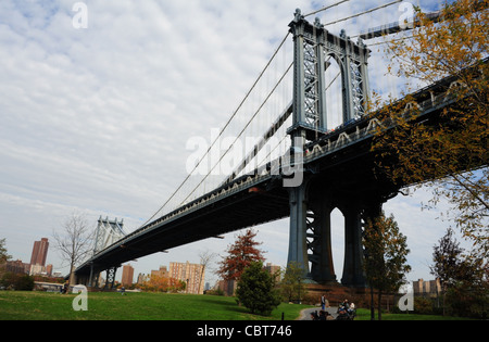 Autumn view of Manhattan Bridge, towards altocumulus clouds sky, from green grass Empire-Fulton Ferry Park, Brooklyn, New York Stock Photo