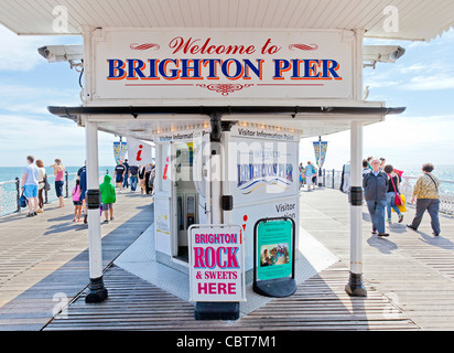 People on holiday and vacation sitting, relaxing, walking and enjoying themselves on the Brighton Pier boardwalk. Stock Photo
